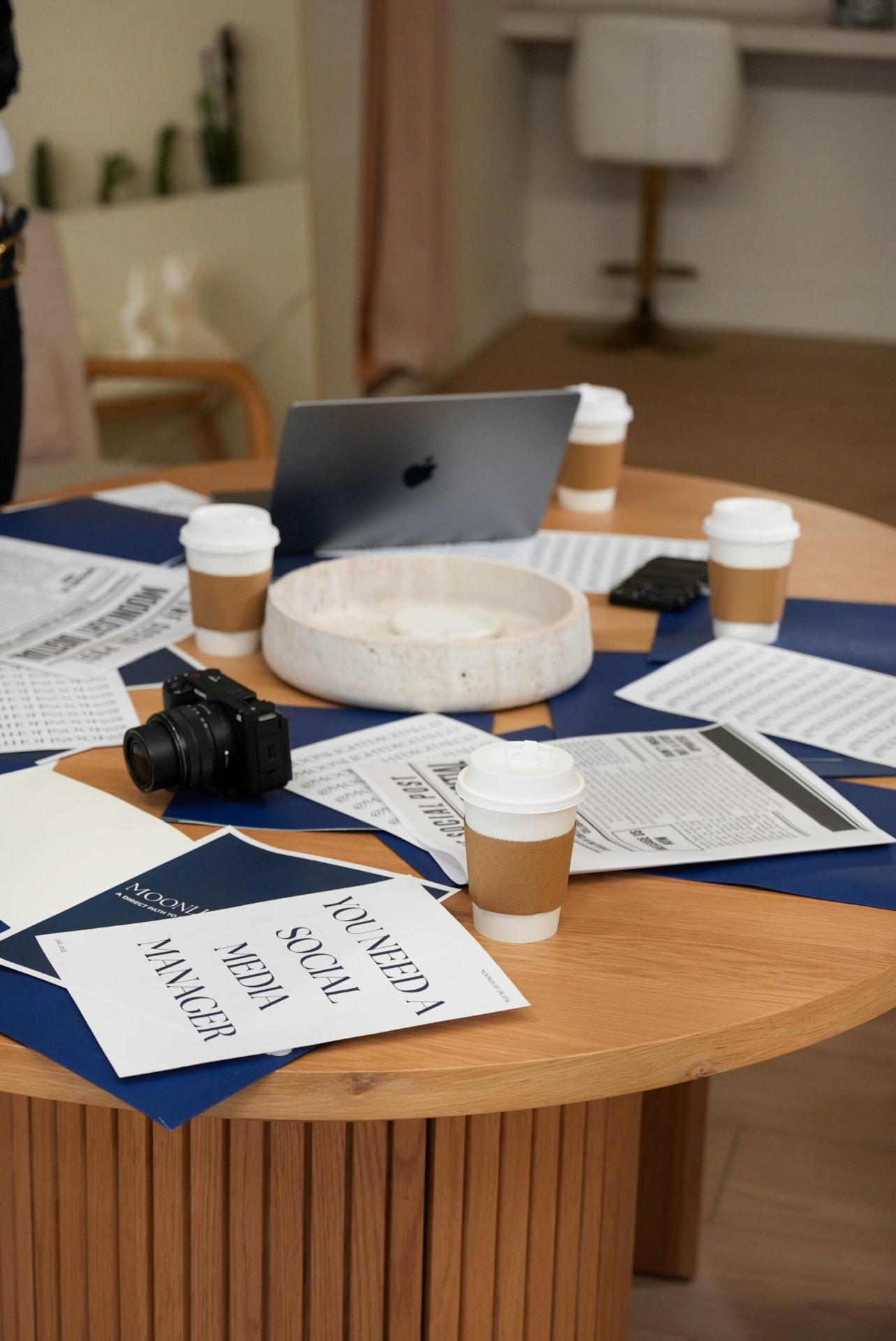Strategy session table with Moonlight print layouts, camera and coffee